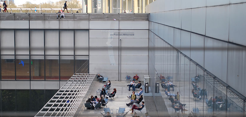 Image of students sitting on a deck studying.