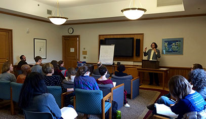 Image of a lecturer standing in front of a classroom.